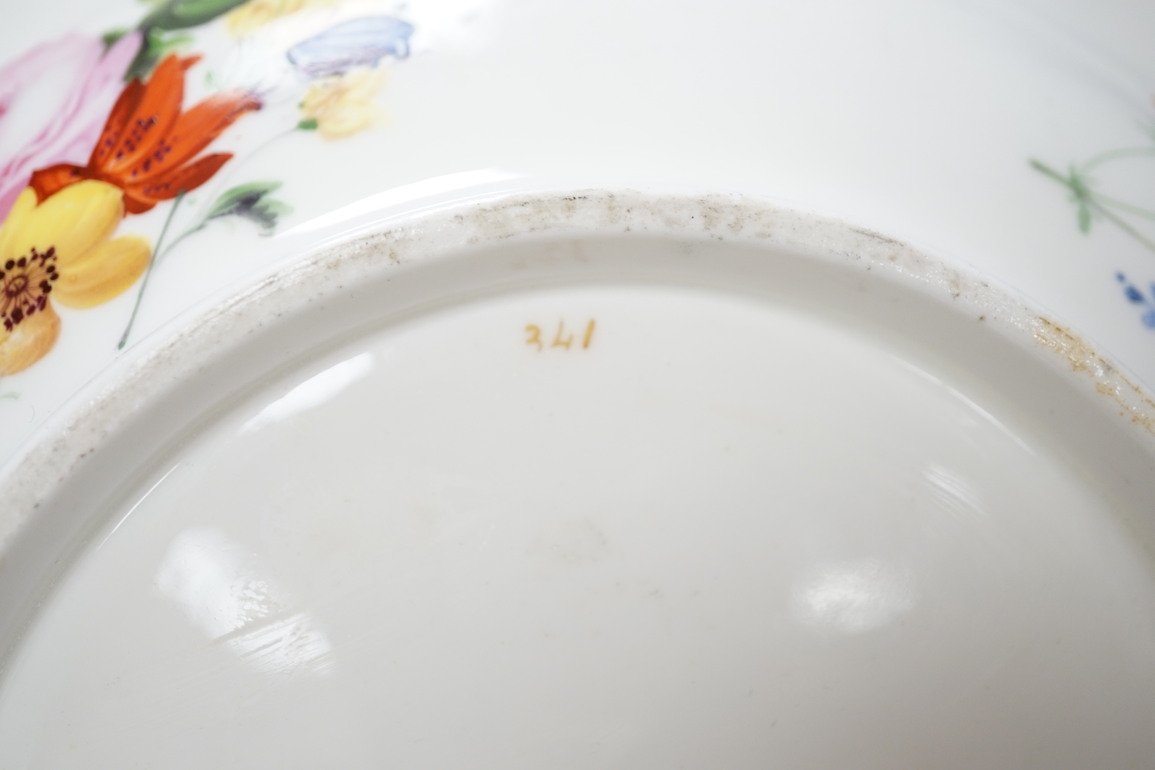 An English porcelain large bowl the centre painted with a bouquet of flowers under a green border with four ornately gilded designs, c.1820, 28cms diameter